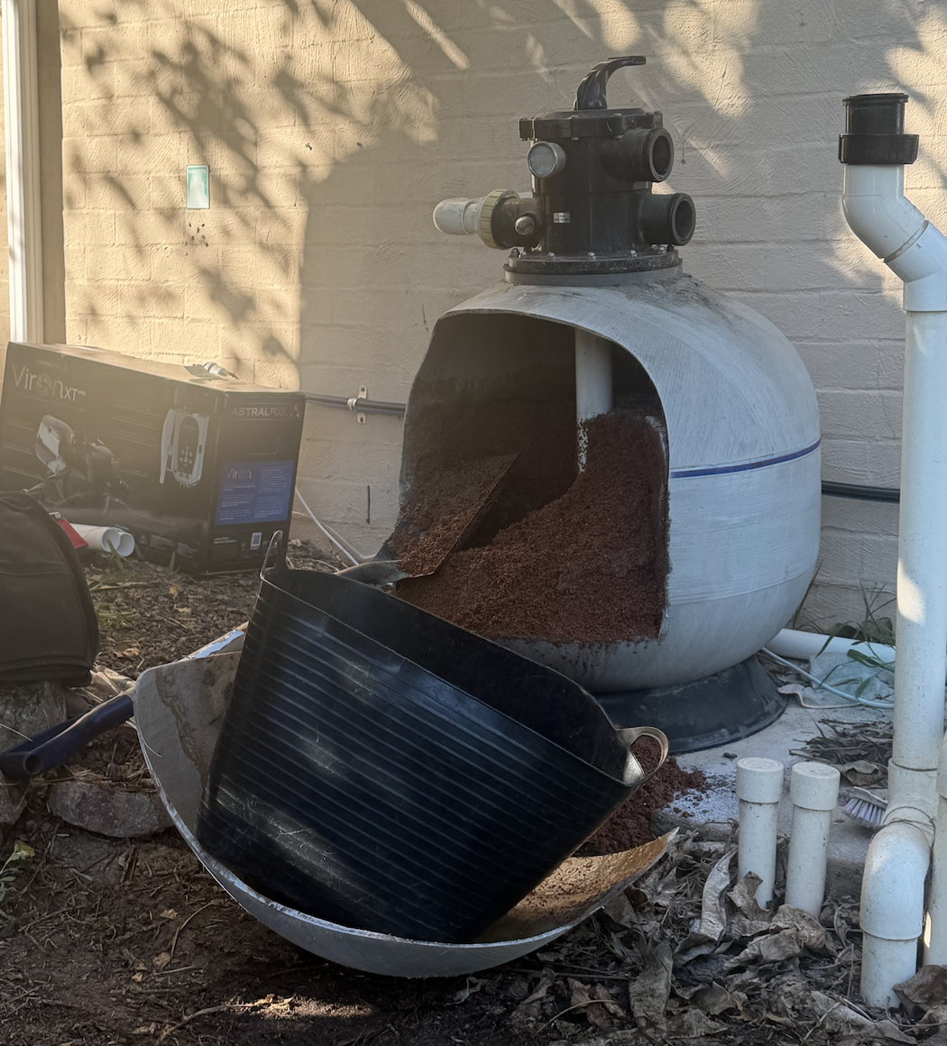 Before: the old pool filter opened up, with filter media exposed